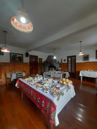 a table with plates of food on it in a room at Pousada Dona Elza in Monte Verde