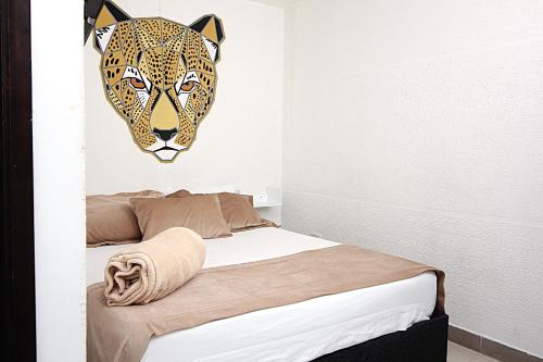 a bedroom with a bed with a leopard head on the wall at DAM Hotel Pereira in Pereira