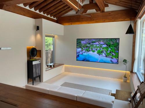 a living room with a white couch and a flat screen tv at Hyu Stay in Gyeongju