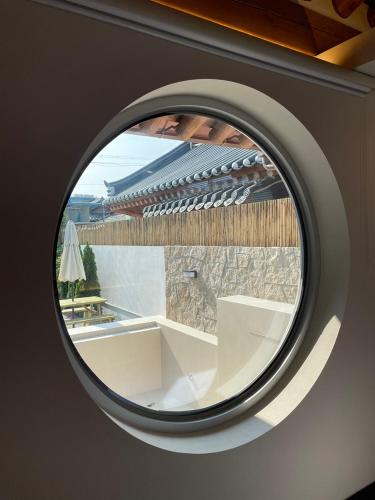 a circular window with a view of a building at Hyu Stay in Gyeongju