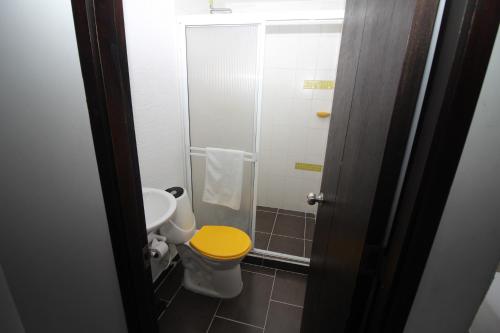 a bathroom with a yellow toilet and a sink at DAM Hotel Pereira in Pereira