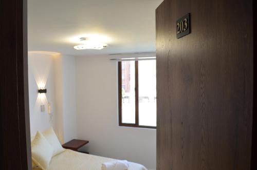 a hotel room with a bed and a window at Hotel Diamond Luxury Tunja in Tunja