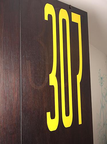 a wooden door with a yellow number on it at DAM Hotel Pereira in Pereira