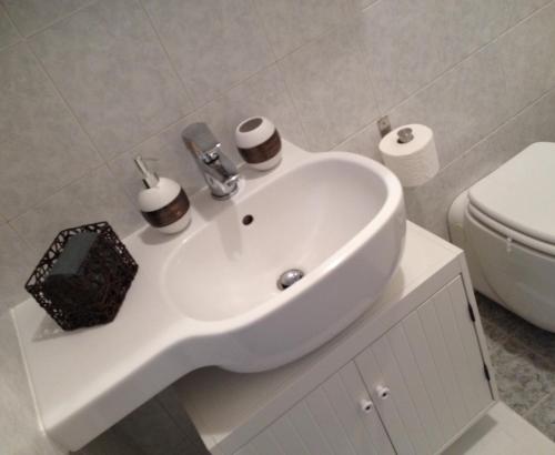een badkamer met een witte wastafel en een toilet bij Lovely Terrace Apartment in Milaan