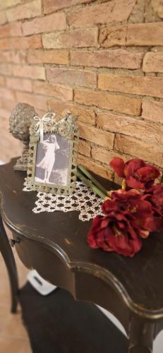 a table with a picture and flowers on it at Lajatico Rentals - Terrazza sul Tramonto del Silenzio in Laiatico