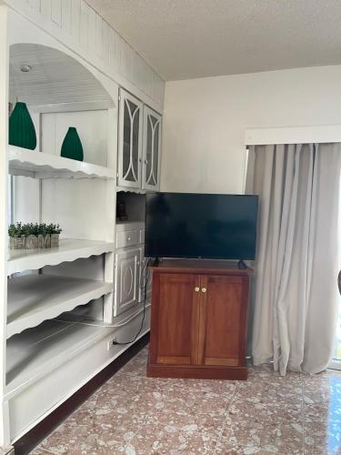 a living room with a flat screen tv and shelves at Peaceful Private Home With Exclusive Swimming Pool in Montego Bay
