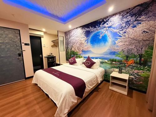 a bedroom with a bed with a large painting on the wall at Venus Boutique Hotel in Melaka