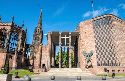 a large brick building with a cross on the side at Luxury 2 Guest House, Parking with EV , WIFI AND NETFLIX in Coventry