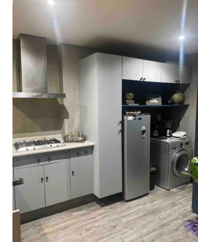 a kitchen with white cabinets and a refrigerator at Habitaciones SkY VIEW in Mexico City