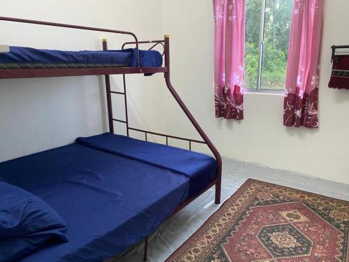 a bedroom with two bunk beds and a rug at D'Bendang Homestay in Tumpat