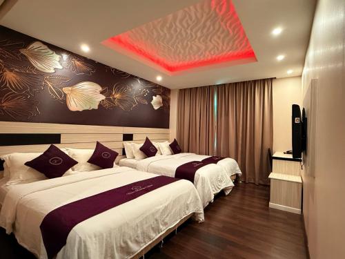 a hotel room with two beds and a television at Venus Boutique Hotel in Melaka