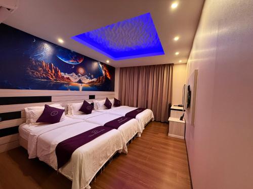 a bedroom with two beds and a blue ceiling at Venus Boutique Hotel in Melaka