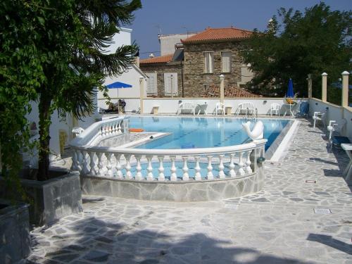 a large swimming pool with a white fence around it at Apartments Zafiria in Ágios Konstantínos