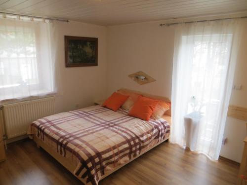 ein Schlafzimmer mit einem Bett mit orangefarbenen Kissen in der Unterkunft Studio Lipa in Maribor