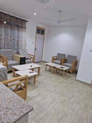 a room with couches and tables and chairs at Jade luxury apartments Diani in Mombasa