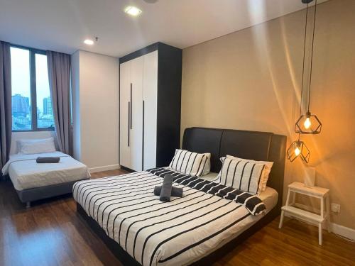 a bedroom with two beds and a window with at Mercu Summer Suites Bernice KLCC in Kuala Lumpur