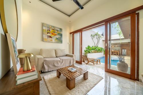 a living room with a couch and a table at Villa Five Smile Ungasan in Badung