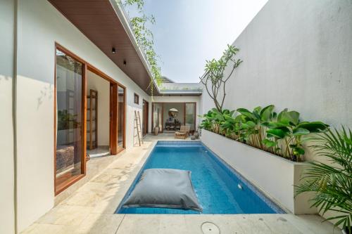an indoor pool in a house with plants at Villa Five Smile Ungasan in Badung