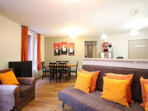 un salon avec un canapé et une salle à manger dans l'établissement Bel F3 en hyper centre du Mont Dore, 50m des Thermes, 7 couchages, tout équipé, classé 2 étoiles - FR-1-415-14, à Le Mont-Dore