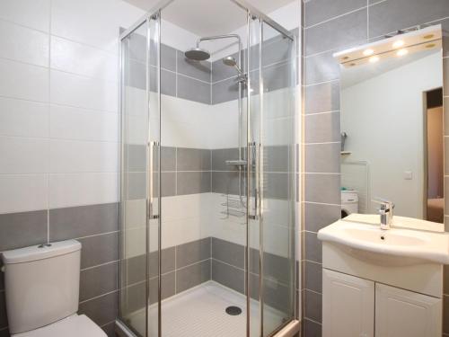 une salle de bain avec une douche, des toilettes et un lavabo dans l'établissement Bel F3 en hyper centre du Mont Dore, 50m des Thermes, 7 couchages, tout équipé, classé 2 étoiles - FR-1-415-14, à Le Mont-Dore