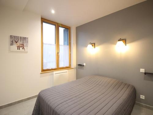 une chambre avec un lit et une fenêtre dans l'établissement Bel F2 au 3e étage avec ascenseur, parking privé, wifi, cuisine équipée et local à skis - Mont-Dore - FR-1-415-70, à Le Mont-Dore