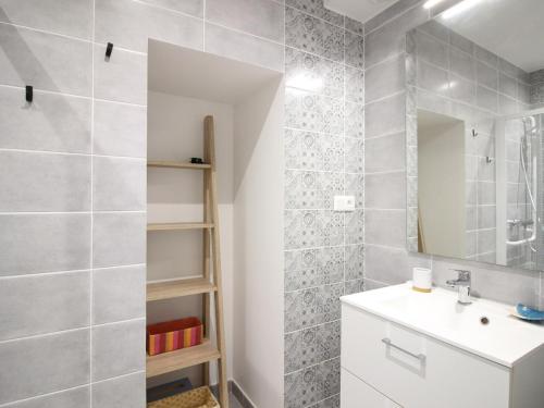 une salle de bain avec un lavabo et un miroir dans l'établissement Bel F2 au 3e étage avec ascenseur, parking privé, wifi, cuisine équipée et local à skis - Mont-Dore - FR-1-415-70, à Le Mont-Dore