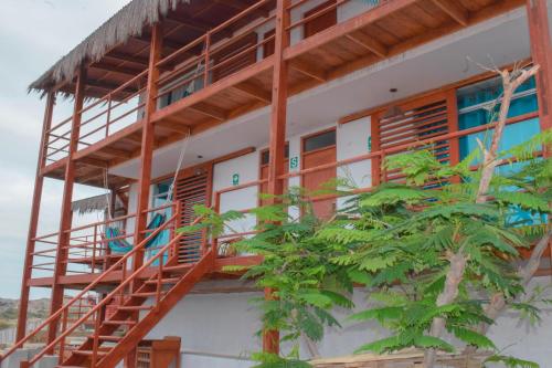 a building with wooden stairs and a tree at Mangata in Lobitos