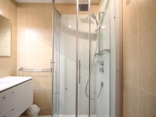 une douche avec une porte vitrée dans une salle de bain dans l'établissement Bel F3 au 2ème étage, à 50m des Thermes, bien équipé, 6 couchages, idéal pour cures et vacances - FR-1-415-65, à Le Mont-Dore