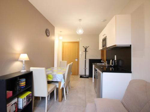 une cuisine et une salle à manger avec une table et des chaises dans l'établissement Appartement F2 de 28m² avec Parking Privé, Wifi et Ascenseur, à 200m des Thermes au Mont-Dore. - FR-1-415-68, à Le Mont-Dore