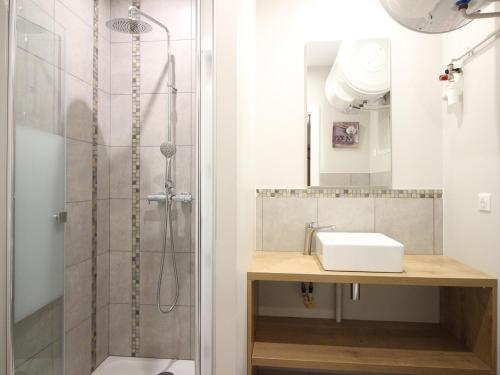 une salle de bain avec douche et lavabo dans l'établissement Appartement F2 de 28m² avec Parking Privé, Wifi et Ascenseur, à 200m des Thermes au Mont-Dore. - FR-1-415-68, à Le Mont-Dore