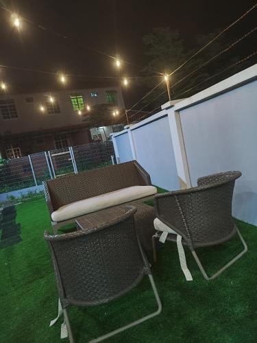 a picnic table and two chairs on the grass at night at LUXURY Modern House Kubang Kerian UNIFI 4 Bedrooms in Kota Bharu