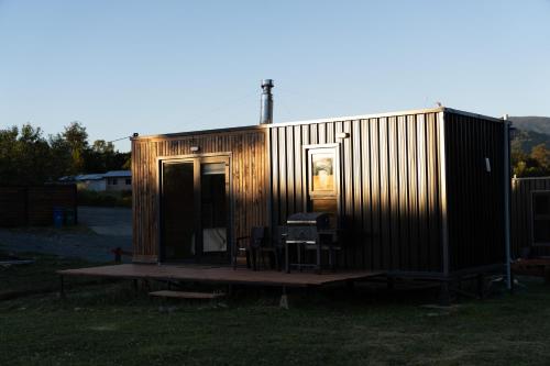 a small shed with a table and chairs in a field at Puerta austral in Puelo