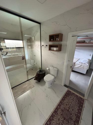 a bathroom with a toilet and a walk in shower at Refúgio nascer das águas in Gravatal
