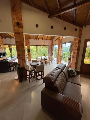 a living room with a couch and a table and chairs at Refúgio nascer das águas in Gravatal
