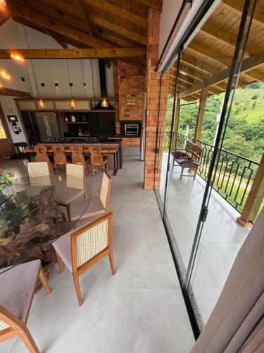 a dining room with tables and chairs and windows at Refúgio nascer das águas in Gravatal