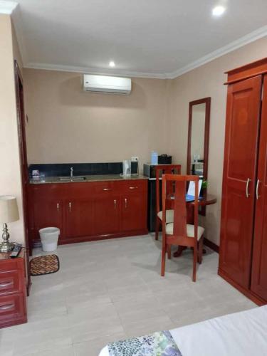 a room with a kitchen with a table and a chair at Ocean Breeze Resort in Toledo City
