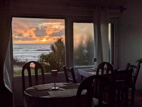 a dining room with a table and a view of the ocean at Guesthouse Entre Campo y Mar in La Coronilla