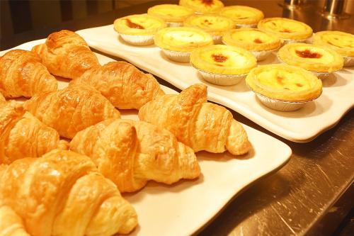 a bunch of croissants and cupcakes on trays on a table at Sanya Begonia Four Seasons in Sanya