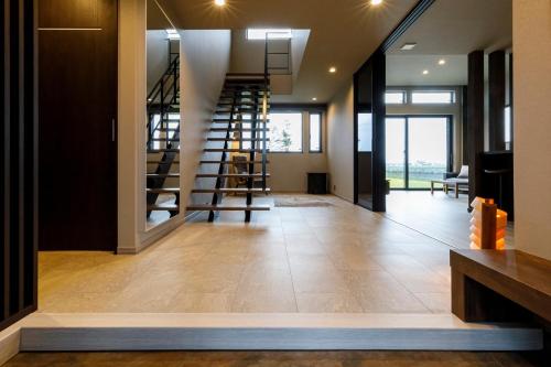 a hallway with a staircase in a house at Blooming Villa Higashikawa in Higashikawa