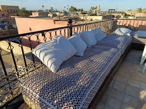 a bench on a balcony with pillows on it at Riad Palais Bahia - Entire House - 5 Bedrooms in Marrakech
