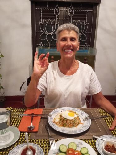 a woman sitting at a table with a plate of food at Dishari Tangalle in Tangalle