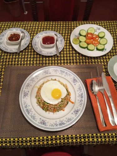 a table topped with plates of food with an egg on it at Dishari Tangalle in Tangalle
