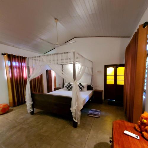 un dormitorio con una cama con mosquitera en Jargoon paradise, en Unawatuna