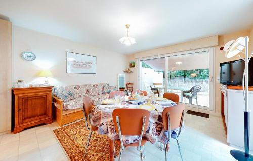 une salle à manger avec une table et un canapé dans l'établissement Nice Home In Saint-Georges-De-Didon, à Saint-Georges-de-Didonne