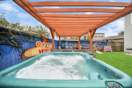 a hot tub in a backyard with a wooden pergola at Vibrant Vegas Vibes - Hot Tub & Games - Perfect 4 Family & Groups in Houston