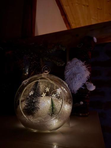 a glass snow globe with a christmas tree inside at Drveni san Senović 2 in Banja