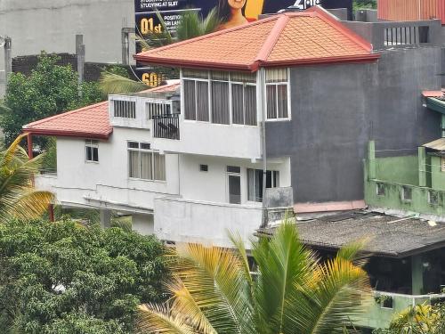 a tall white building with a red roof at Kandy home in Kandy