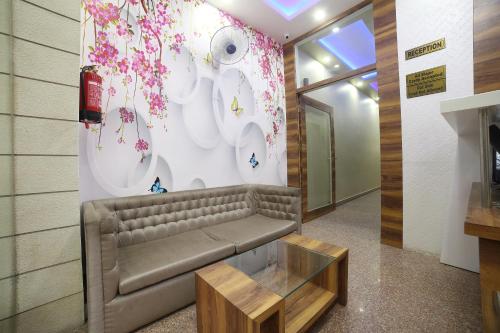 a lobby with a couch and flowers on the wall at Hotel O Jai Ambay International in Jaipur