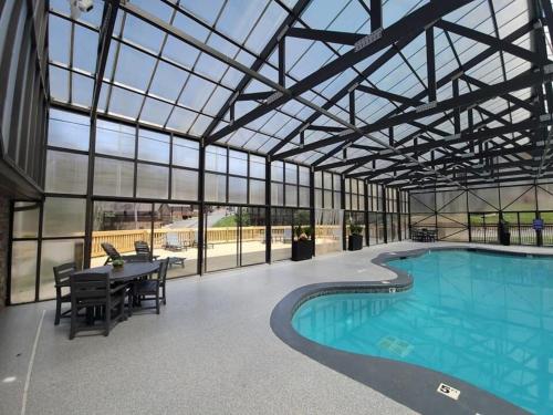 a large indoor pool with a glass ceiling and a table and chairs at Beautiful Bear Haven in Sevierville