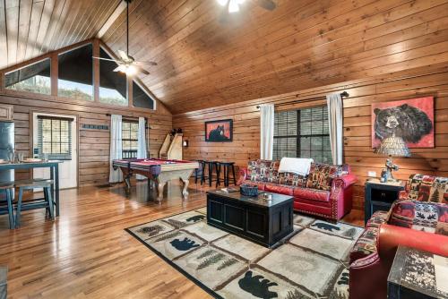 a living room with a red couch and a table at Beautiful Bear Haven in Sevierville